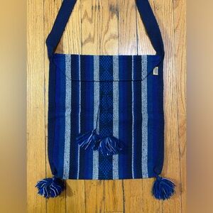 Woven bag with poofs by Pinzón